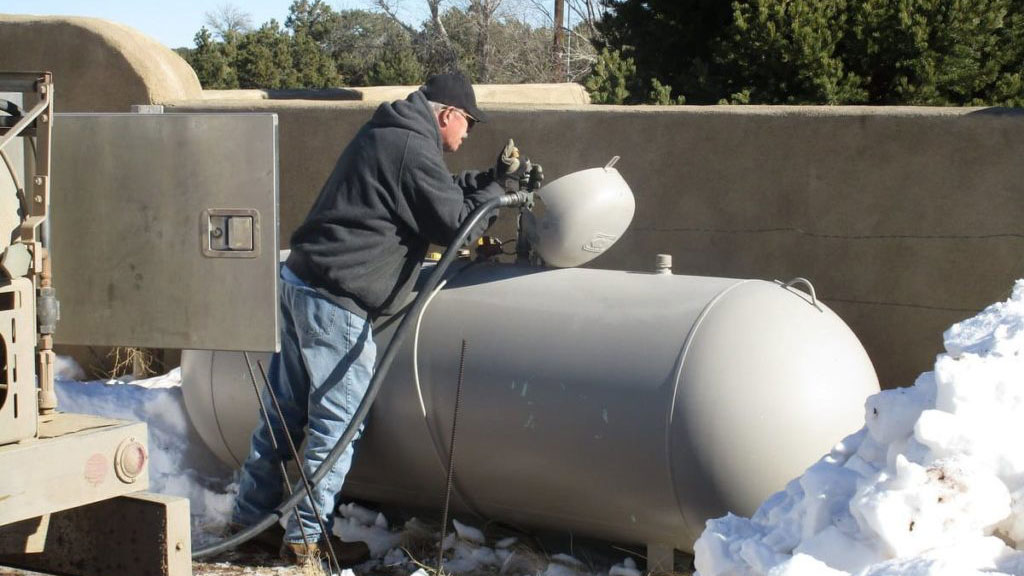 Technicien inspectant installation citerne propane sur site entreprise
